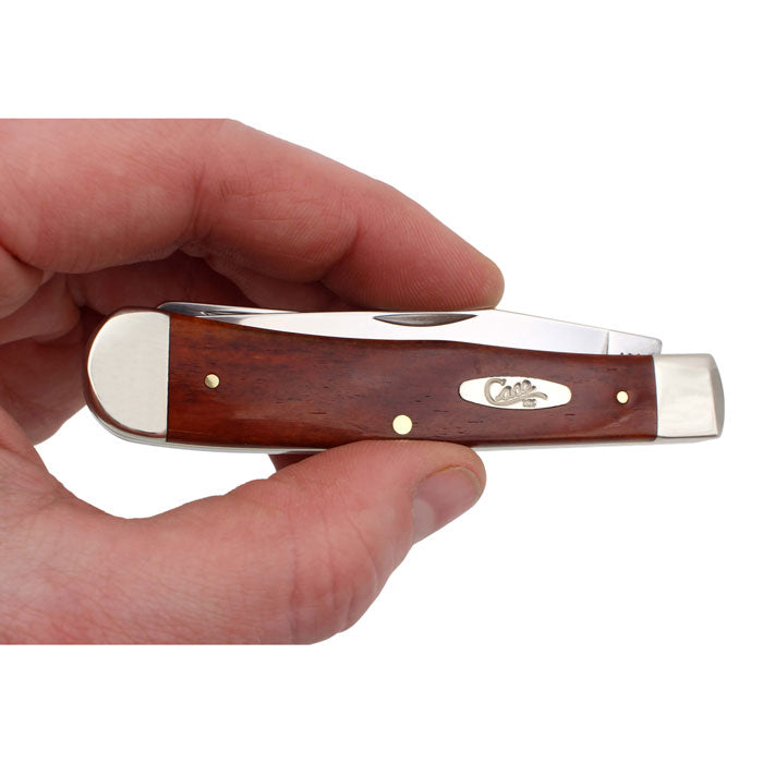 a man holding a case smooth chestnut bone trapper pocket knife