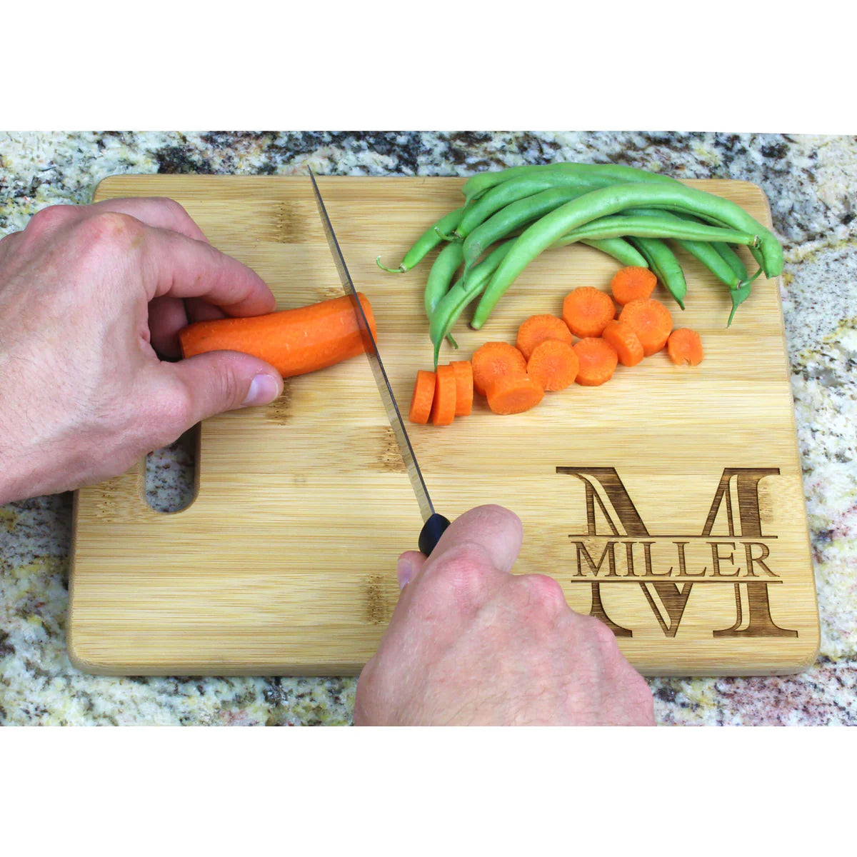 person cutting carrots on a bamboo cutting board