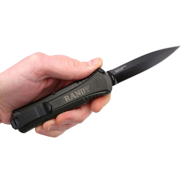 man holding an engraved black pocket knife