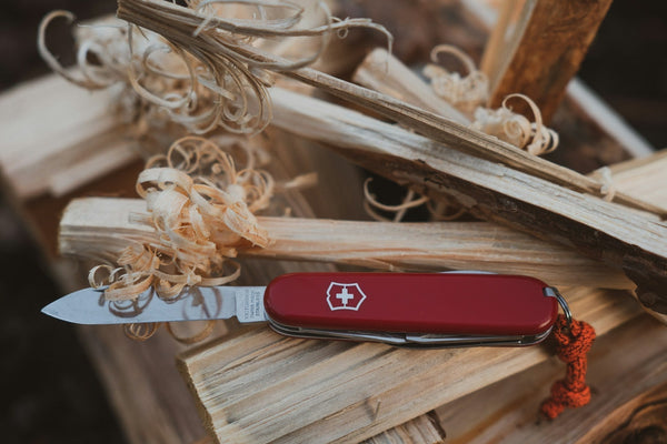 A Victorinox Swiss Army Knife and whittled wood