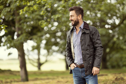 man standing in a field with trees in the background