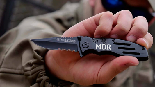 man holding an engraved Smith and Wesson black pocket knife