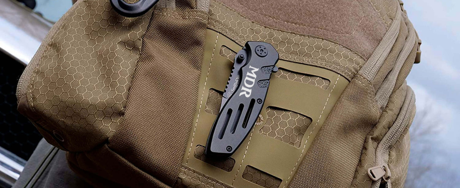 smith and wesson extreme ops engraved pocket knife on a backpack