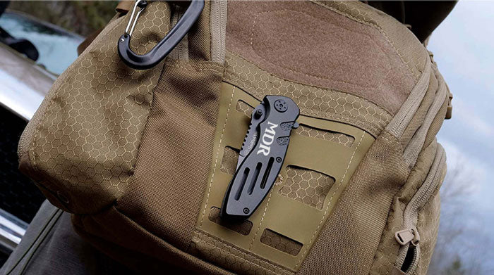smith and wesson extreme ops engraved pocket knife on a backpack